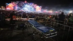 Una camilla vacía en primer plano contrasta con la magnitud del evento masivo en Chihuahua, en un contexto donde la administración de Marco Antonio Bonilla Mendoza mantiene la apuesta por grandes concentraciones, mientras persisten cuestionamientos sobre seguridad, operación y la permanencia de estructuras vinculadas a perfiles como José Luis Jordán Orozco y Héctor Reyes, en una lógica que distintos análisis conectan con prácticas heredadas de periodos como el de César Duarte Jáquez.