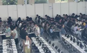 Aspirantes presentan el examen de control de la UNAM en una sede presencial utilizando tabletas digitales bajo supervisión.